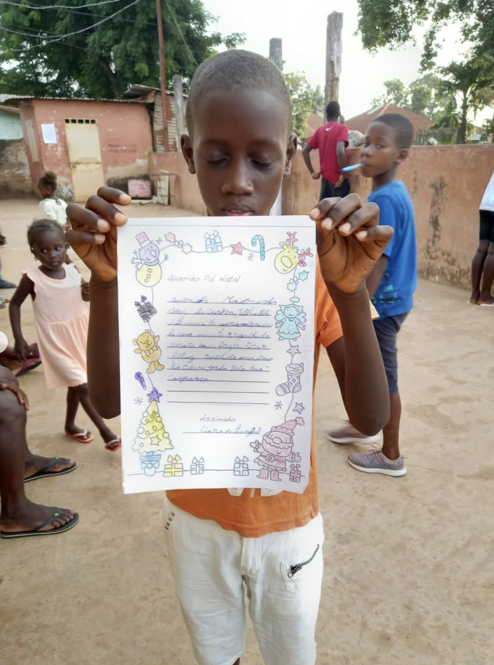 Menino a mostrar a carta que escreveu para o Natal