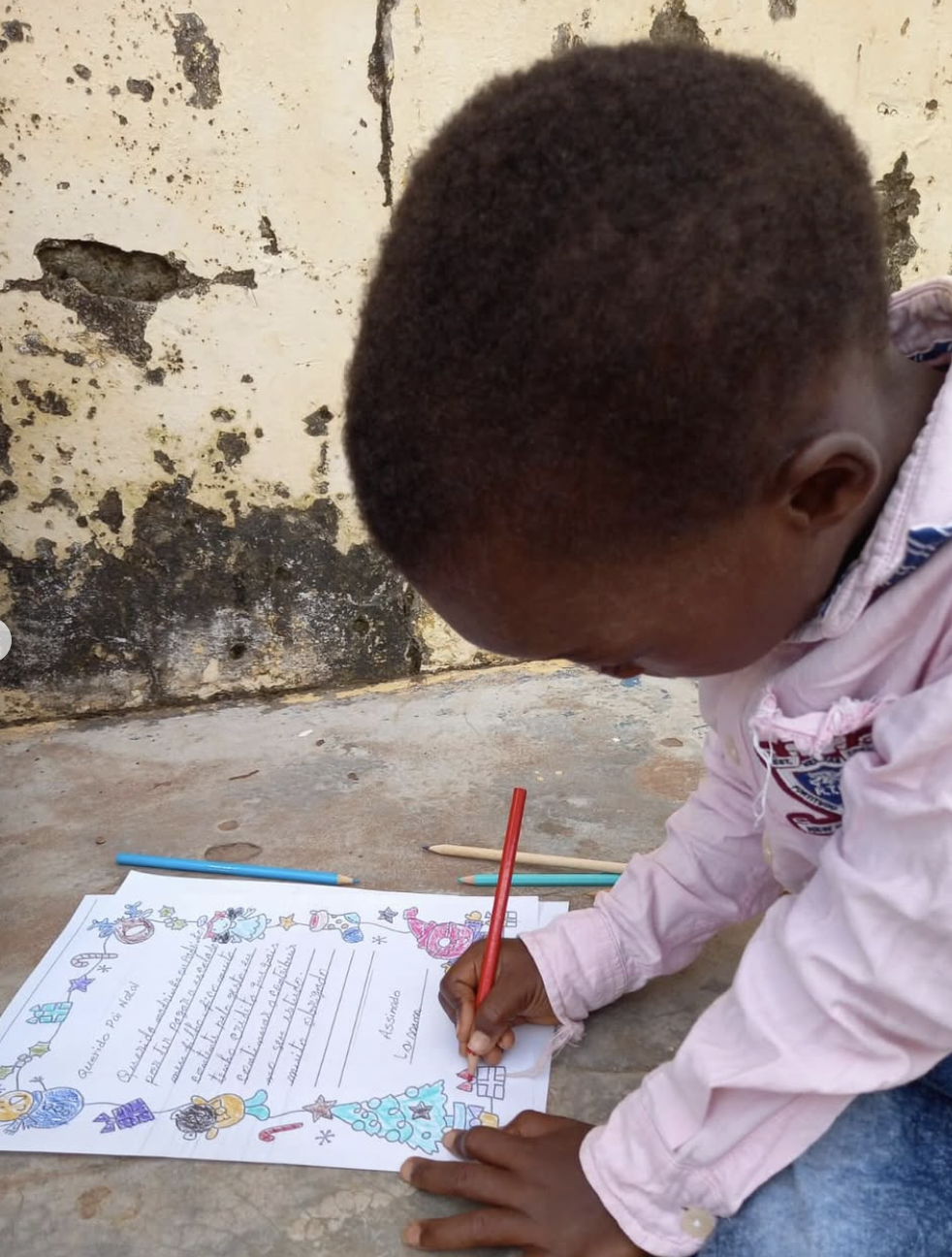 Criança em Bissau a escrever uma Carta ao Pai Natal